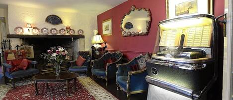 A vintage living room with a fireplace, classic furniture, and a retro radio.