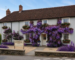 A white building with a tiled roof, windows, and a sign indicating it is a hotel with restaurant and rooms. - Meryan House Hotel (Taunton)