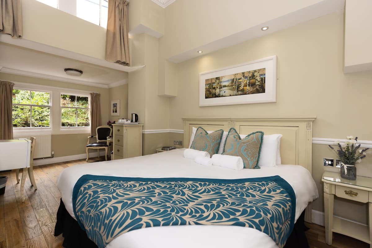 A spacious bedroom with a large bed, a desk, and a chair.