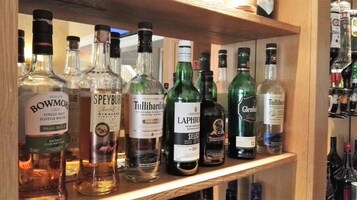 A shelf with various bottles of whisky and spirits.