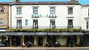 A hotel named West Park with a sign above the entrance, outdoor seating area, and a balcony with flowers. - West Park Hotel (Harrogate)