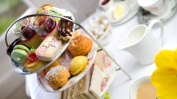 A tea service with a variety of pastries and sandwiches on a tray.