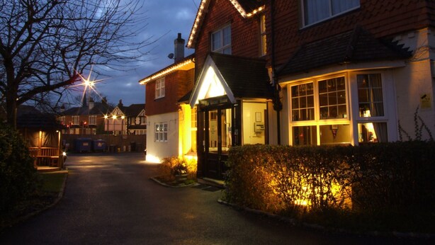 A traditional pub with a welcoming entrance, a visible signboard, and a well-maintained garden area. - The Corner House Hotel Gatwick (Horley)