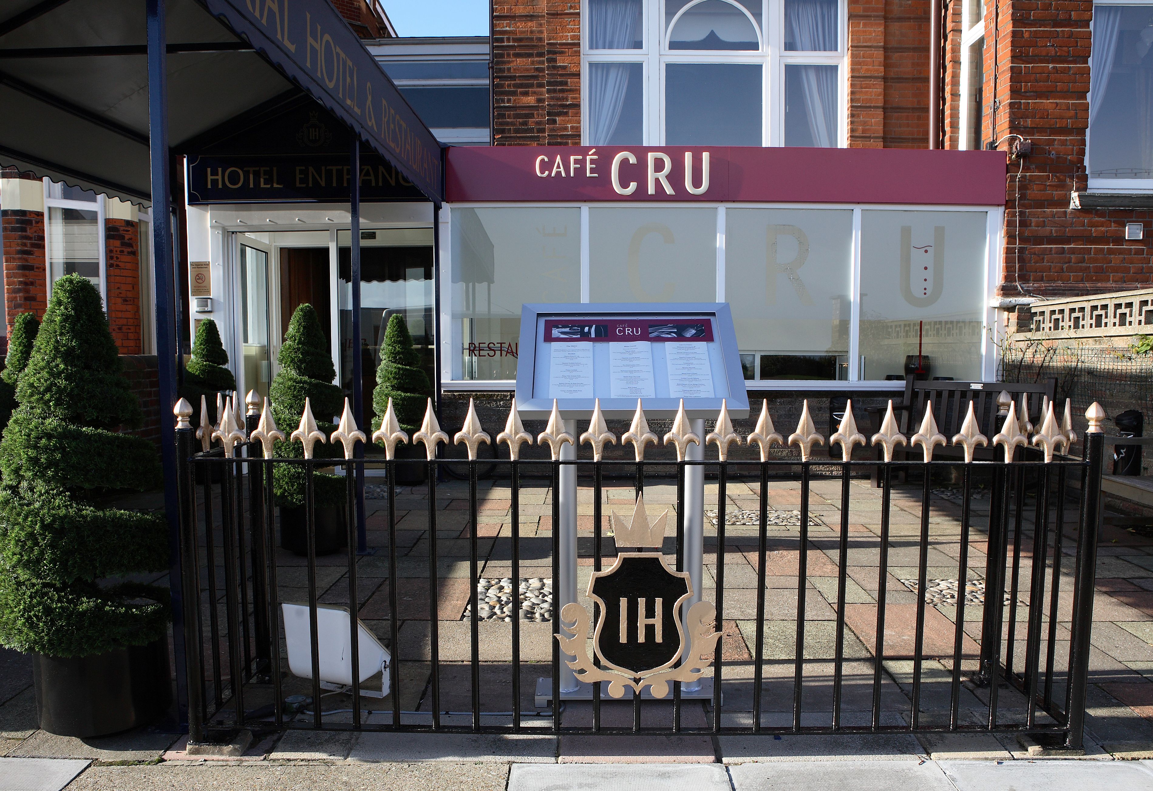 A hotel entrance with a sign for 'Hotel Entrance' and 'Café Cru'.