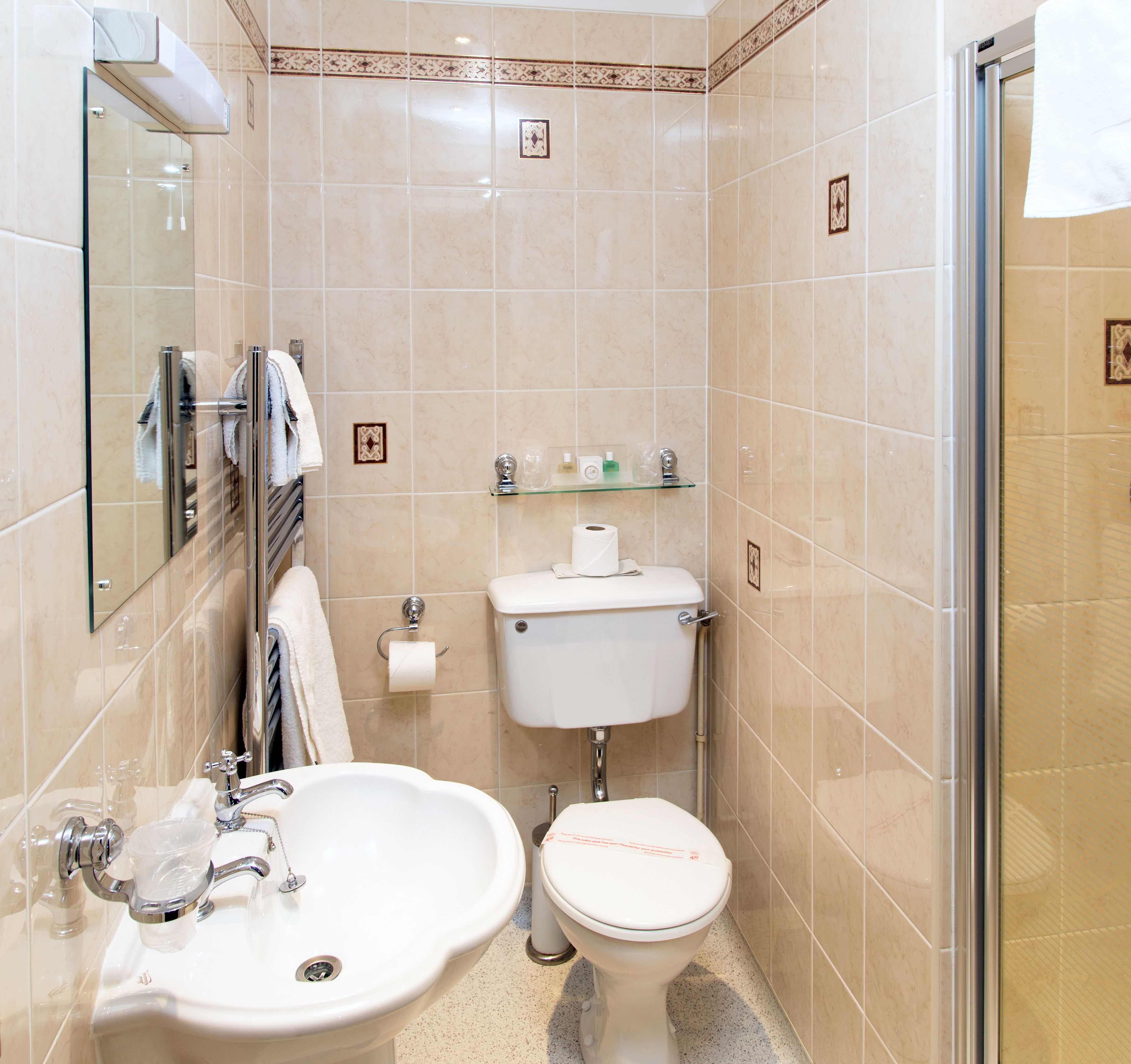 A bathroom with a sink, toilet, and glass shower enclosure.