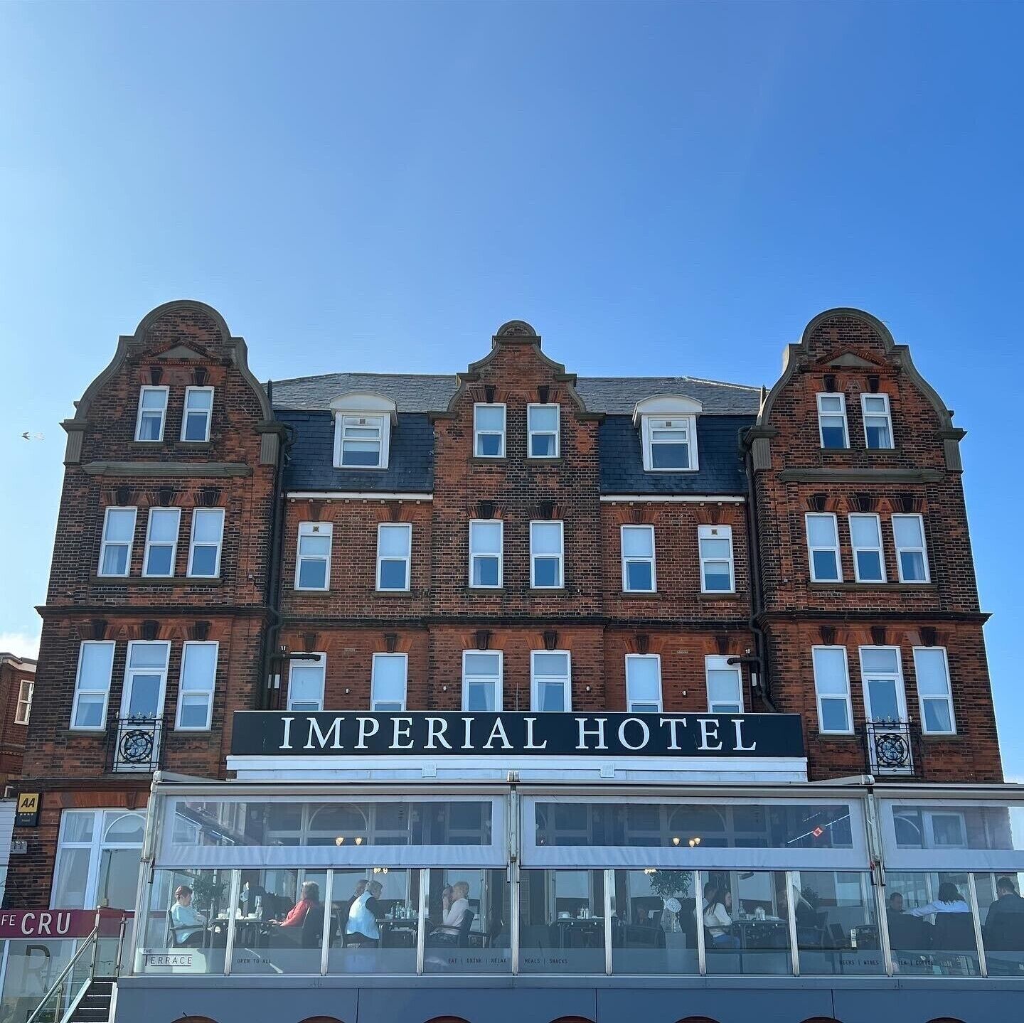 Exterior de l'Hotel Imperial, amb una façana clàssica de maó, nombroses finestres i un cartell amb el nom de l'hotel.