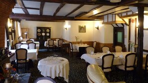 A traditional inn with wooden beams, round tables, and a cozy atmosphere. - The Falcon Hotel (Bromyard)