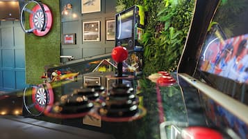 A dartboard mounted on a wall with a dartboard and a dartboard stand on the counter.