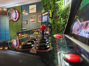A dartboard mounted on a wall with a dartboard and a dartboard stand on the counter. - Knowsley Inn & Lounge (Liverpool)