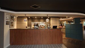 A reception area with a wooden counter, a bar, and a patterned floor. - Knowsley Inn & Lounge (Liverpool)