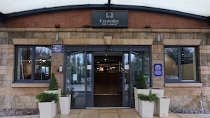 The entrance to Knowsley Inn & Lounge with a brick facade, large glass doors, and potted plants at the entrance. - Knowsley Inn & Lounge (Liverpool)
