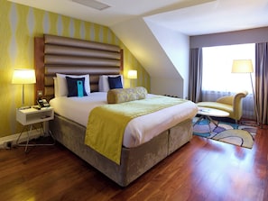 A hotel room with a large bed, bedside lamps, a desk with a phone, and a view of the outdoors. - Hotel Indigo Edinburgh by IHG (Edinburgh)