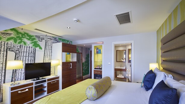 Ein Hotelzimmer mit Bett, Fernseher, Kleiderschrank und Bad.