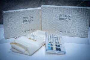 Two Molton Brown London shower caps and a vanity kit.