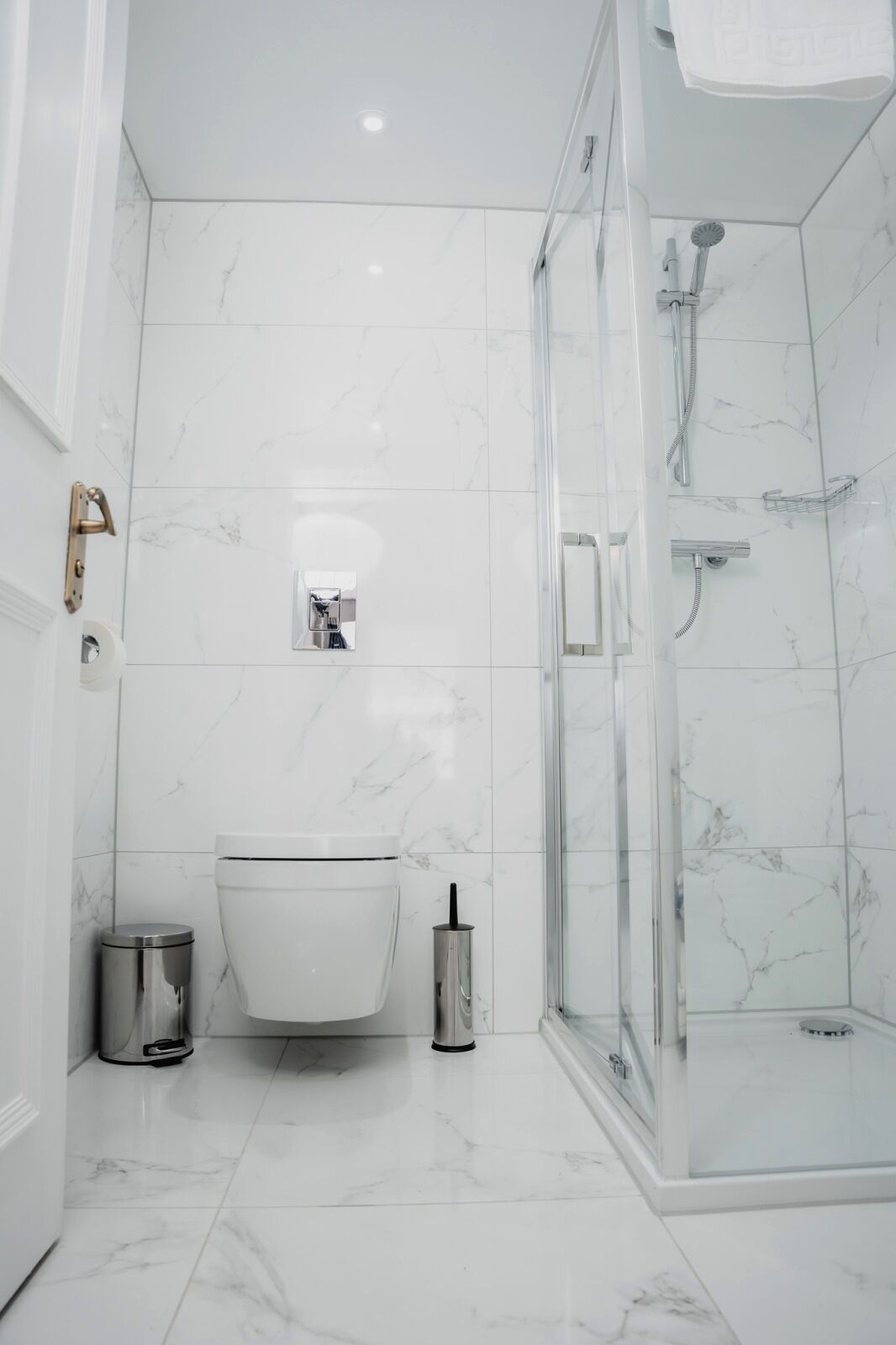 A modern bathroom with a freestanding bathtub, a glass-enclosed shower, and a toilet.