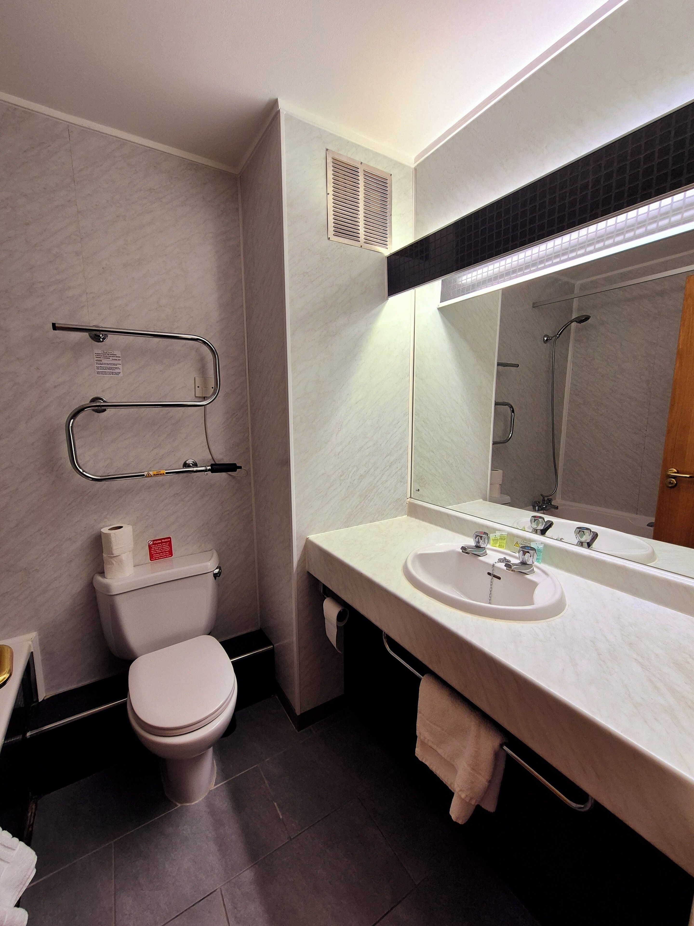 A modern bathroom with a toilet, sink, and shower.