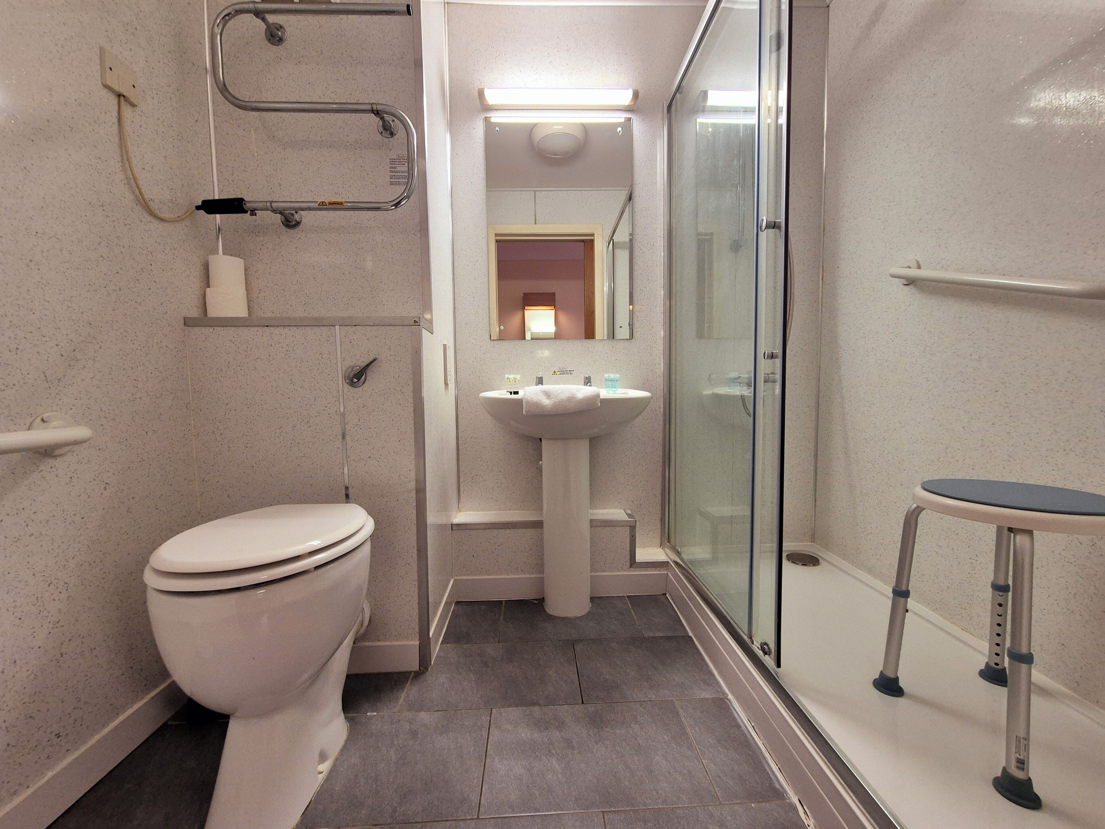 Ein modernes Badezimmer mit Toilette, Waschbecken und Duschkabine aus Glas.