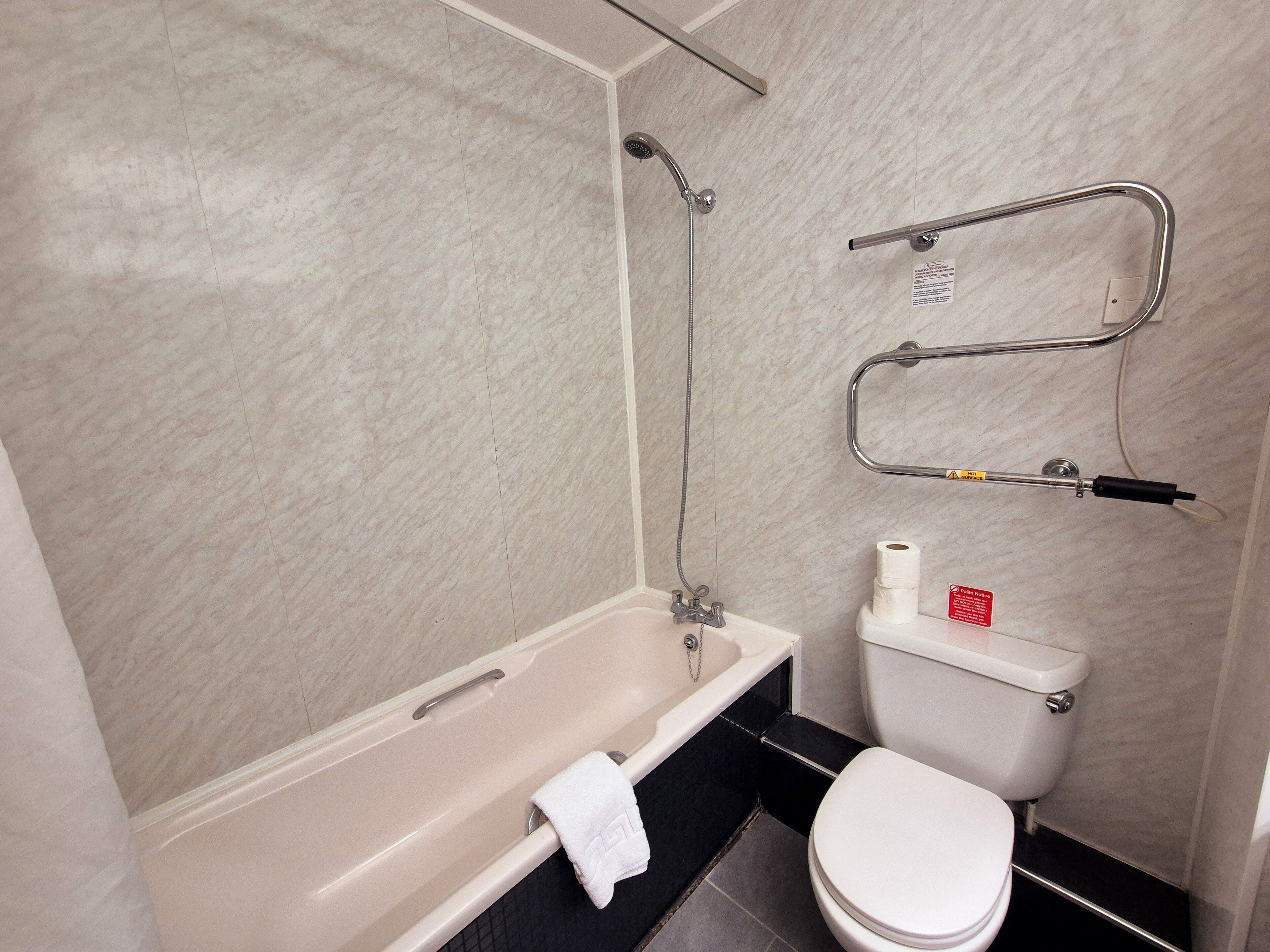 A bathroom with a bathtub, toilet, and shower.