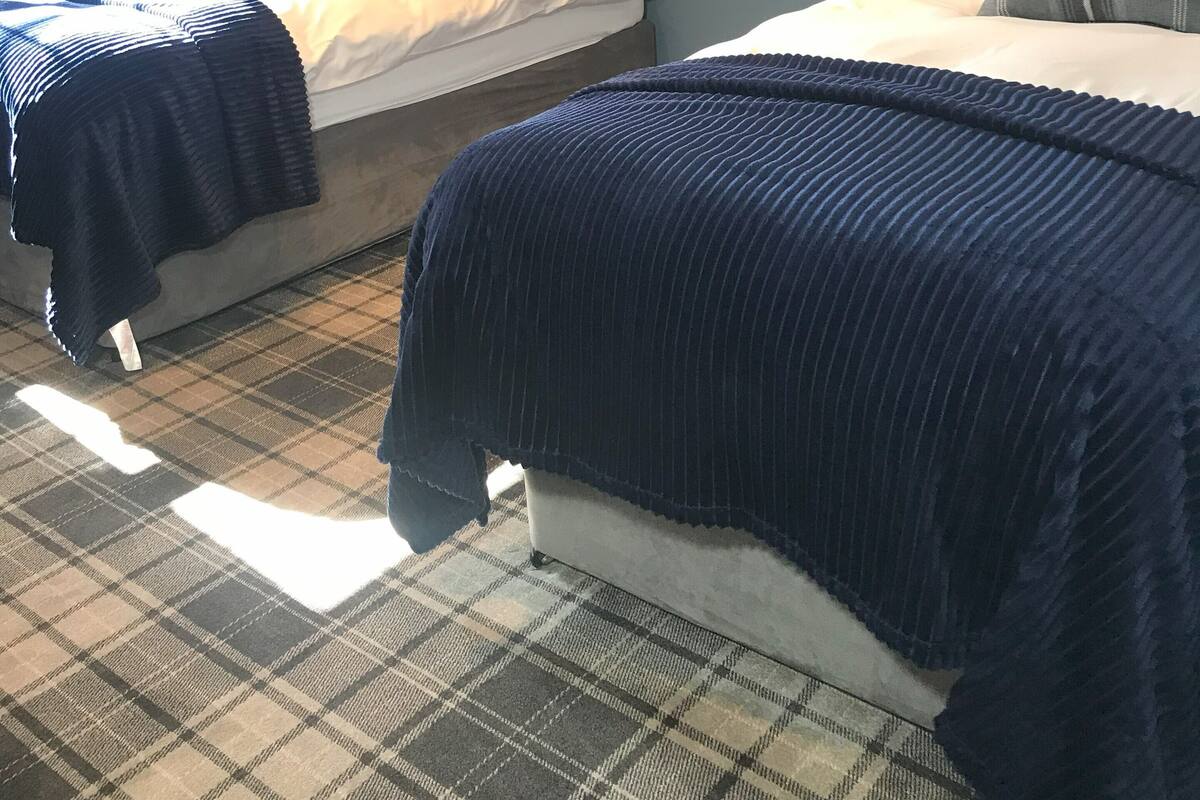 Makuuhuoneessa on kaksi sänkyä, suuri peili ja seinään kiinnitetty valaisin.