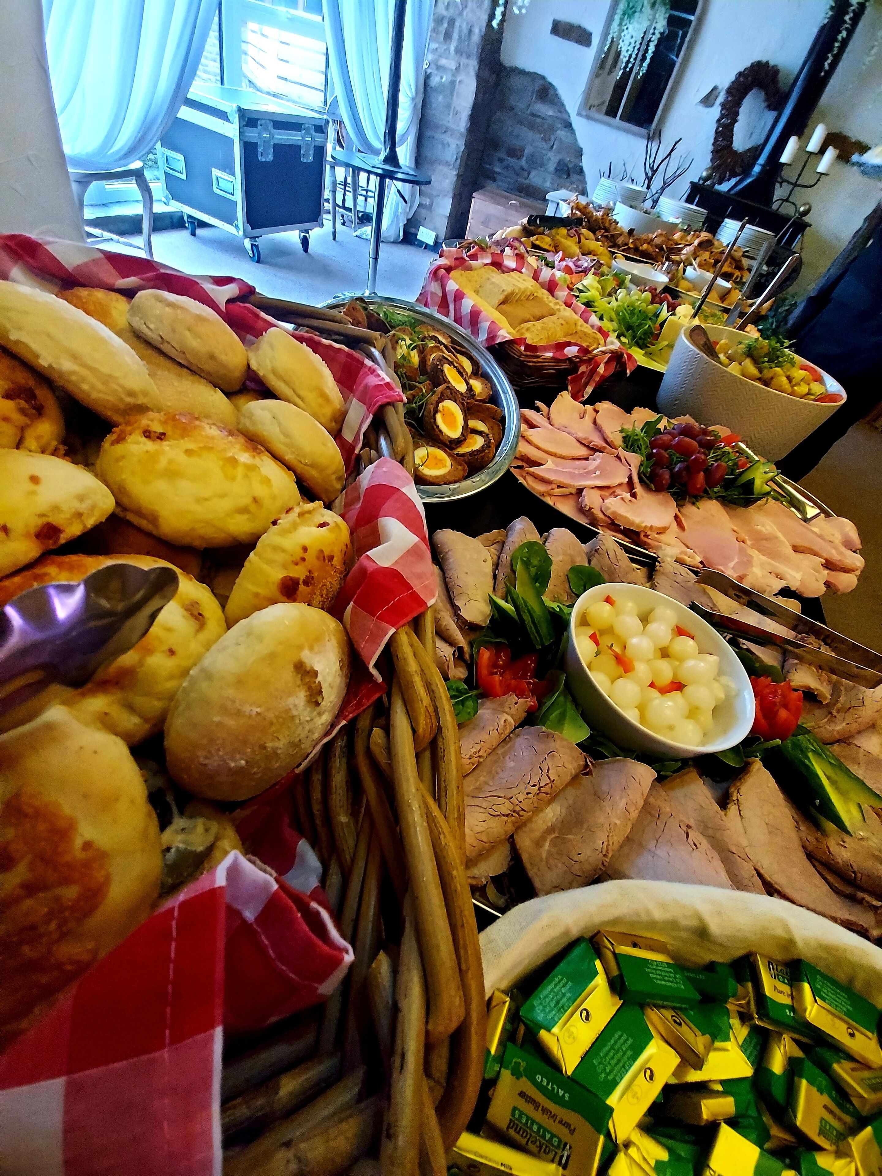 A buffet with various food items including bread, meats, and salads.