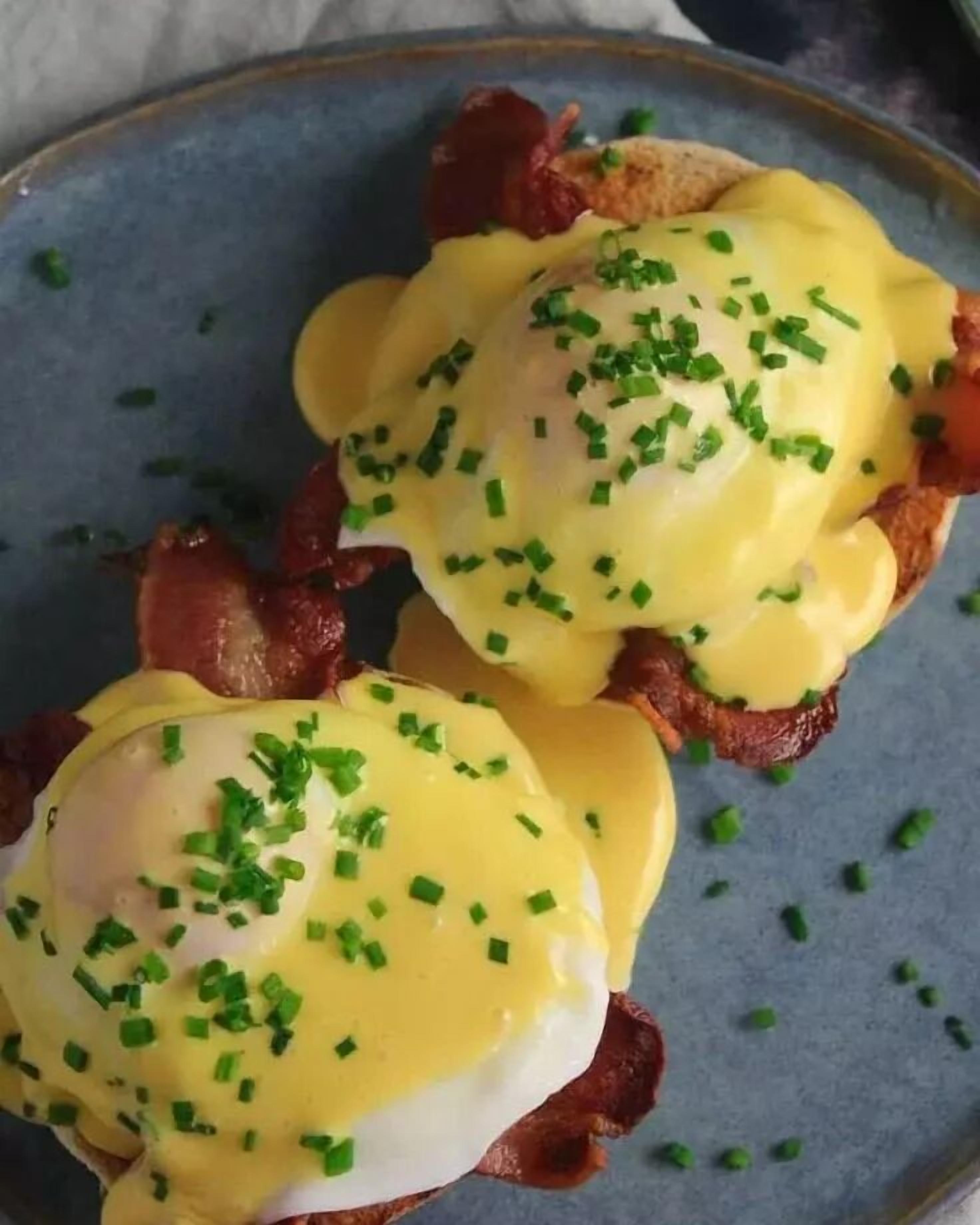 Two eggs benedict sandwiches on a plate.