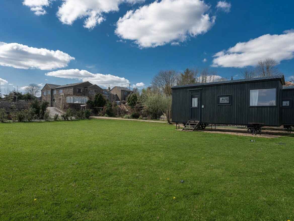 A residential area with a large house and a mobile home.