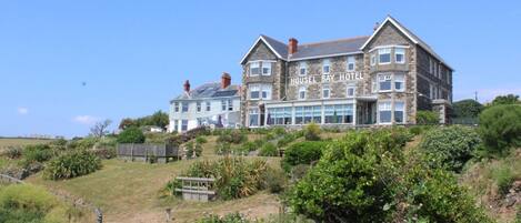 A large, multi-story hotel with a stone facade and a prominent bay window.