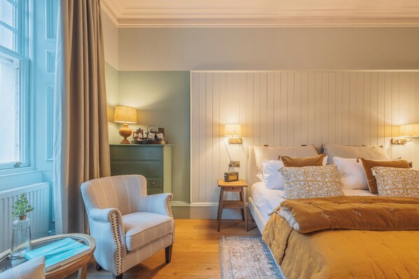 A bedroom with a bed, a chair, a nightstand, a lamp, and a dresser. - Pine Trees Hotel (Pitlochry)