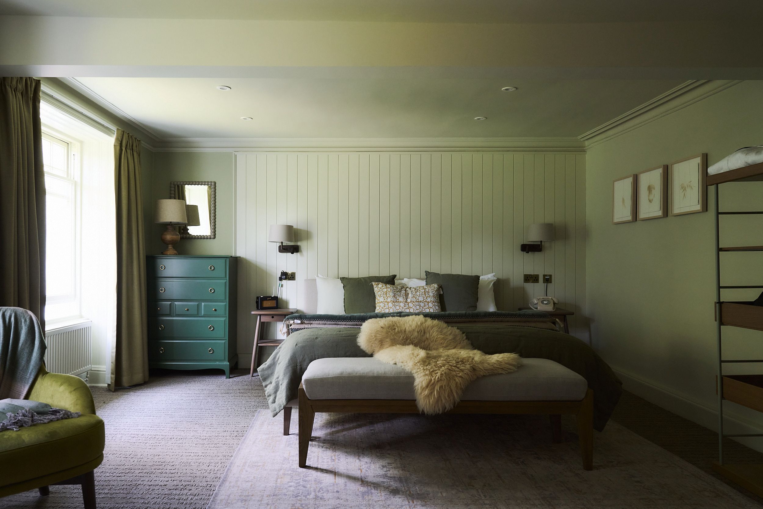 Un dormitorio con cama, cómoda, silla y ventana con cortinas.