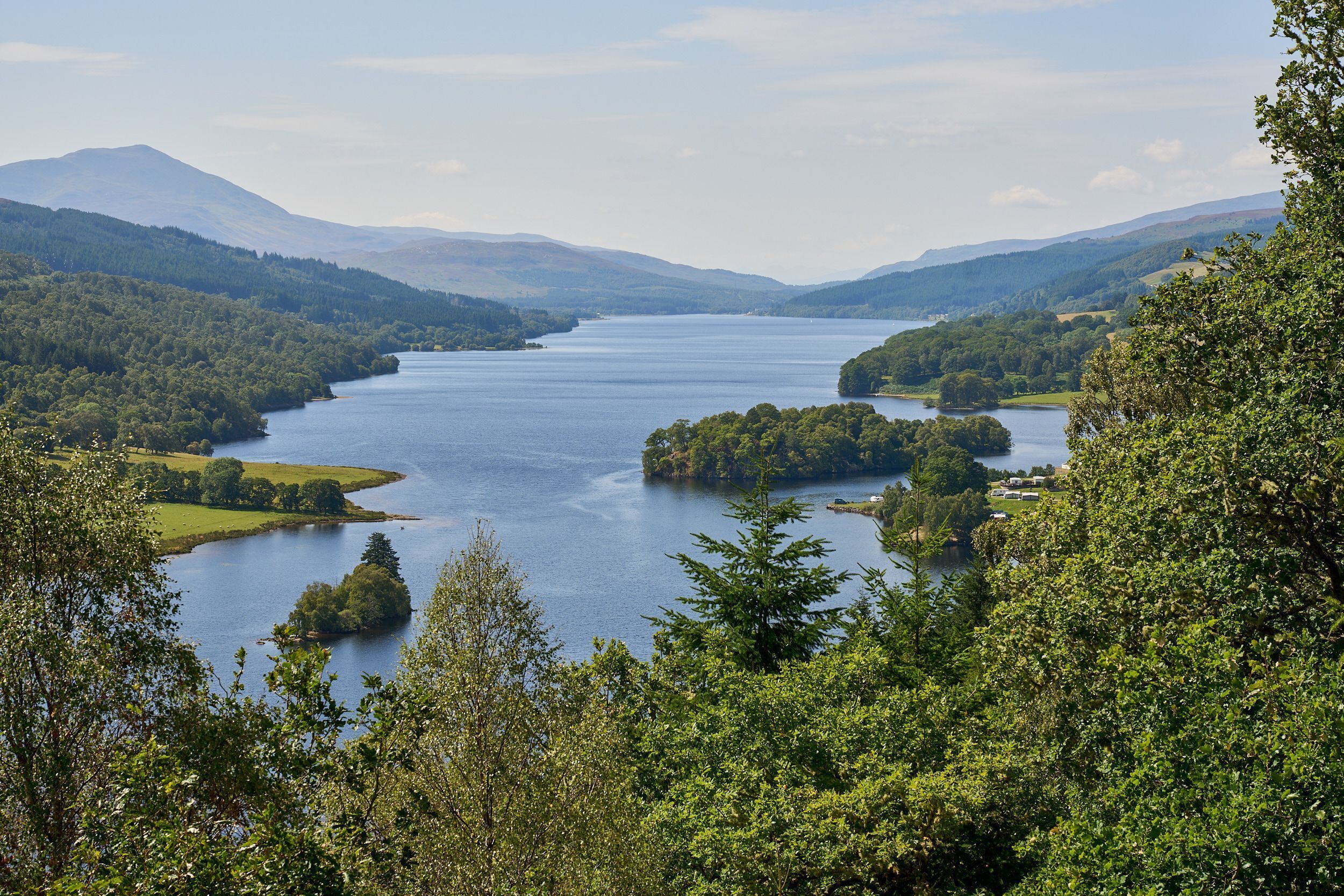 Un lago rodeado de colinas boscosas.