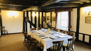 Ein Esszimmer mit einem langen Tisch, gedeckt für eine Mahlzeit, umgeben von Holzsesseln.