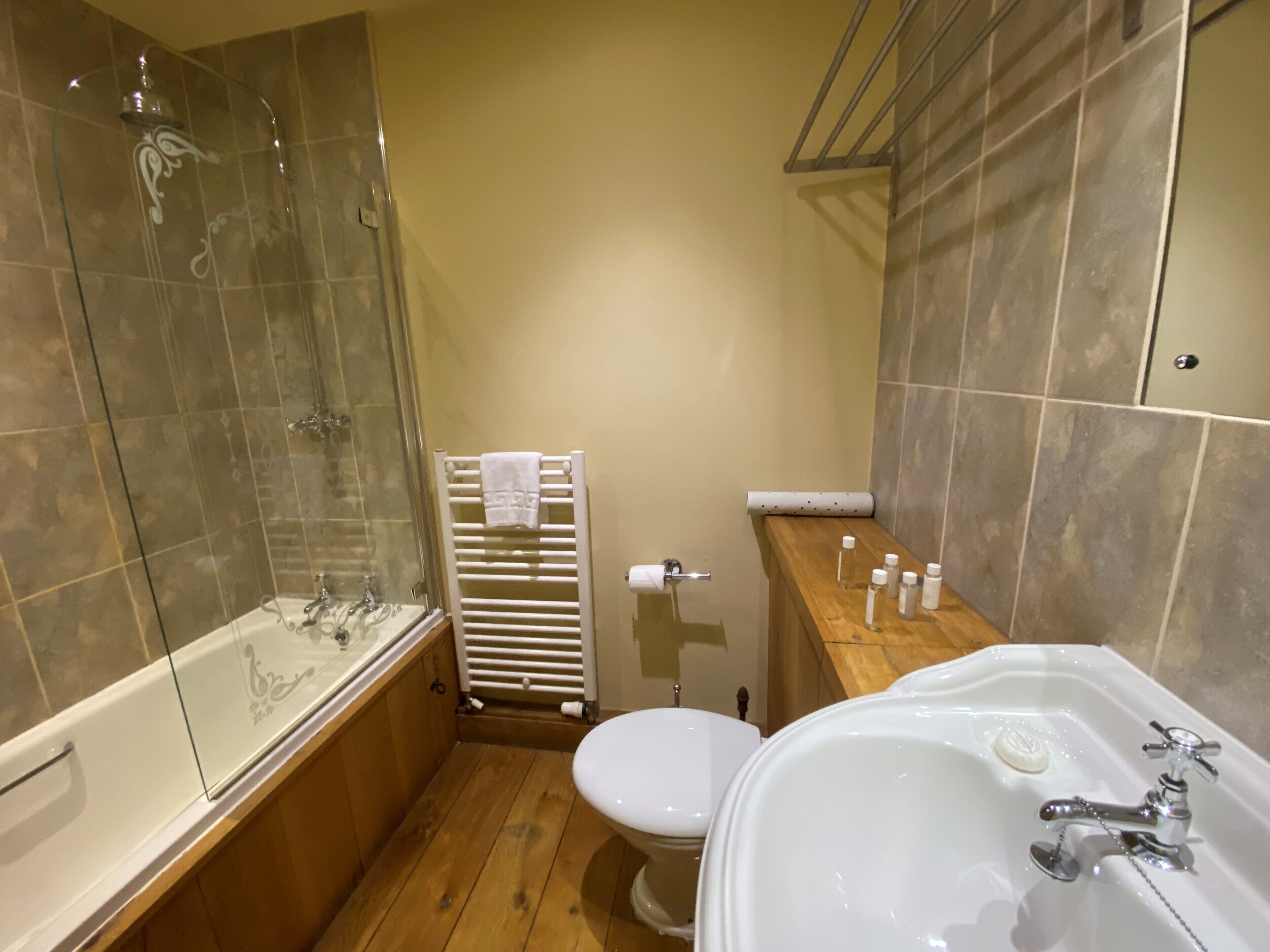 A compact bathroom with a bathtub, toilet, and shower.