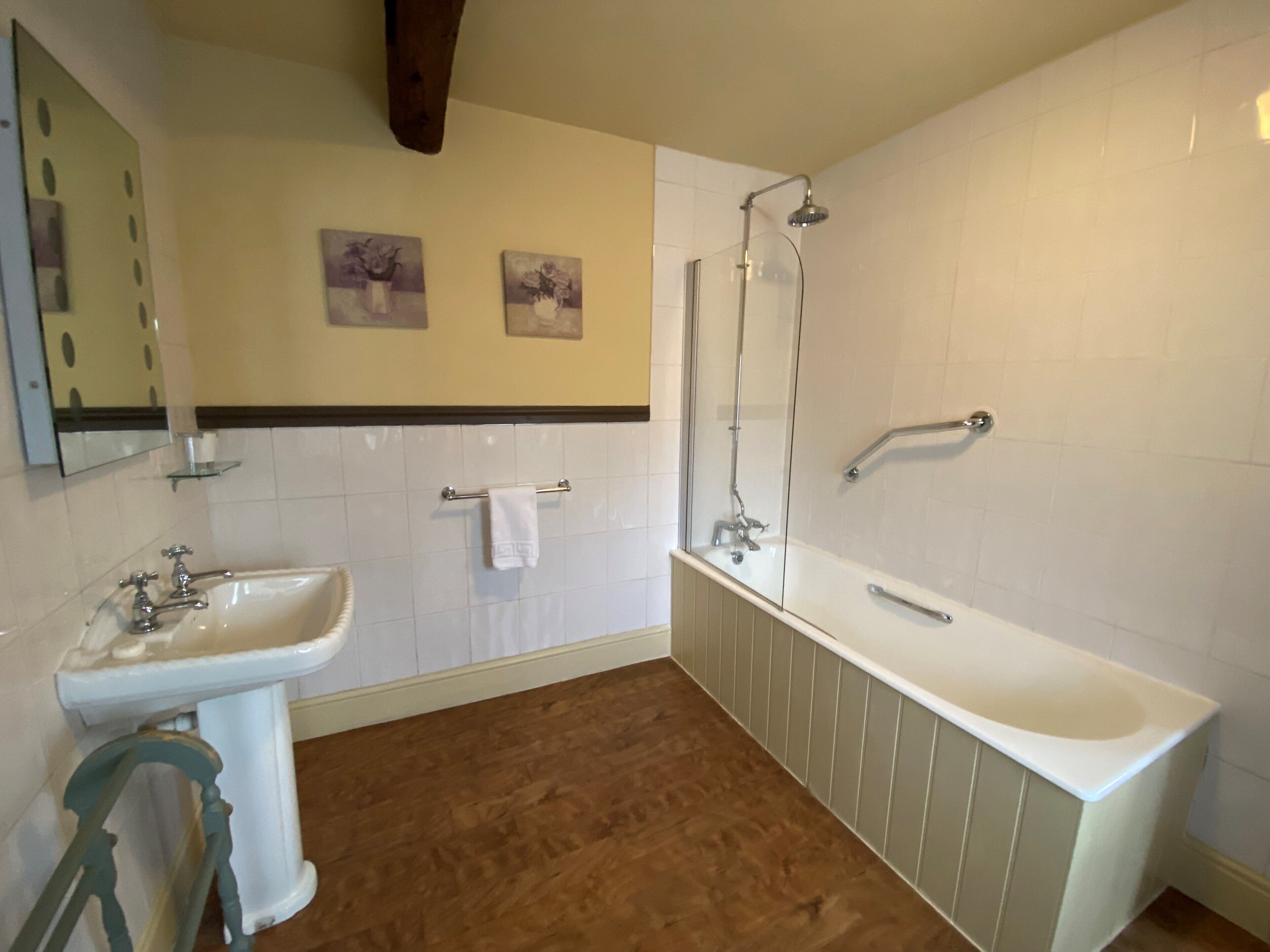 Une salle de bain avec un lavabo blanc, une baignoire et une douche à parois de verre.