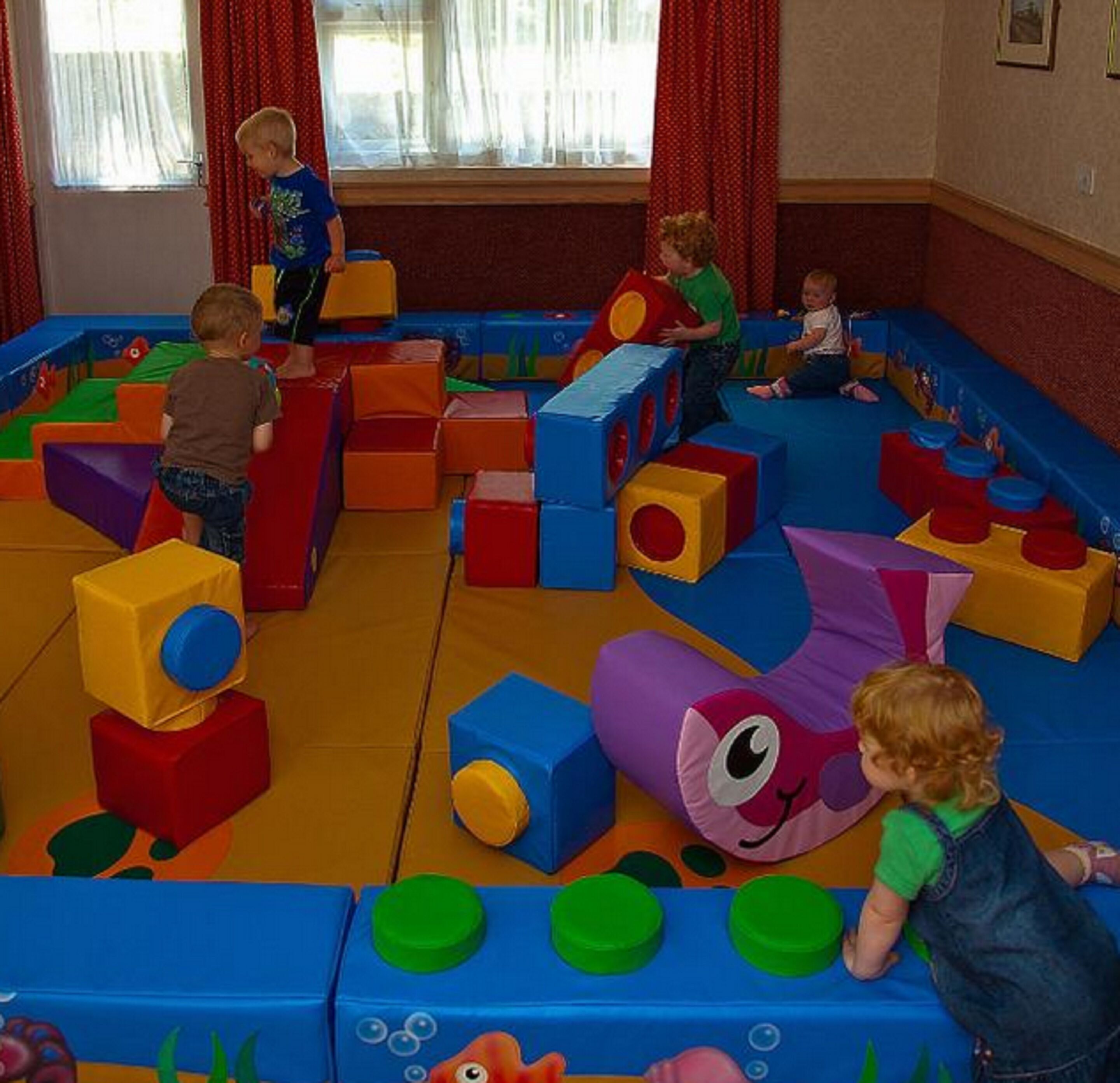 A play area with colorful foam blocks and a soft play surface.