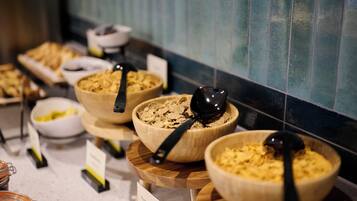 A buffet with various food items in wooden bowls, each with a black serving spoon.