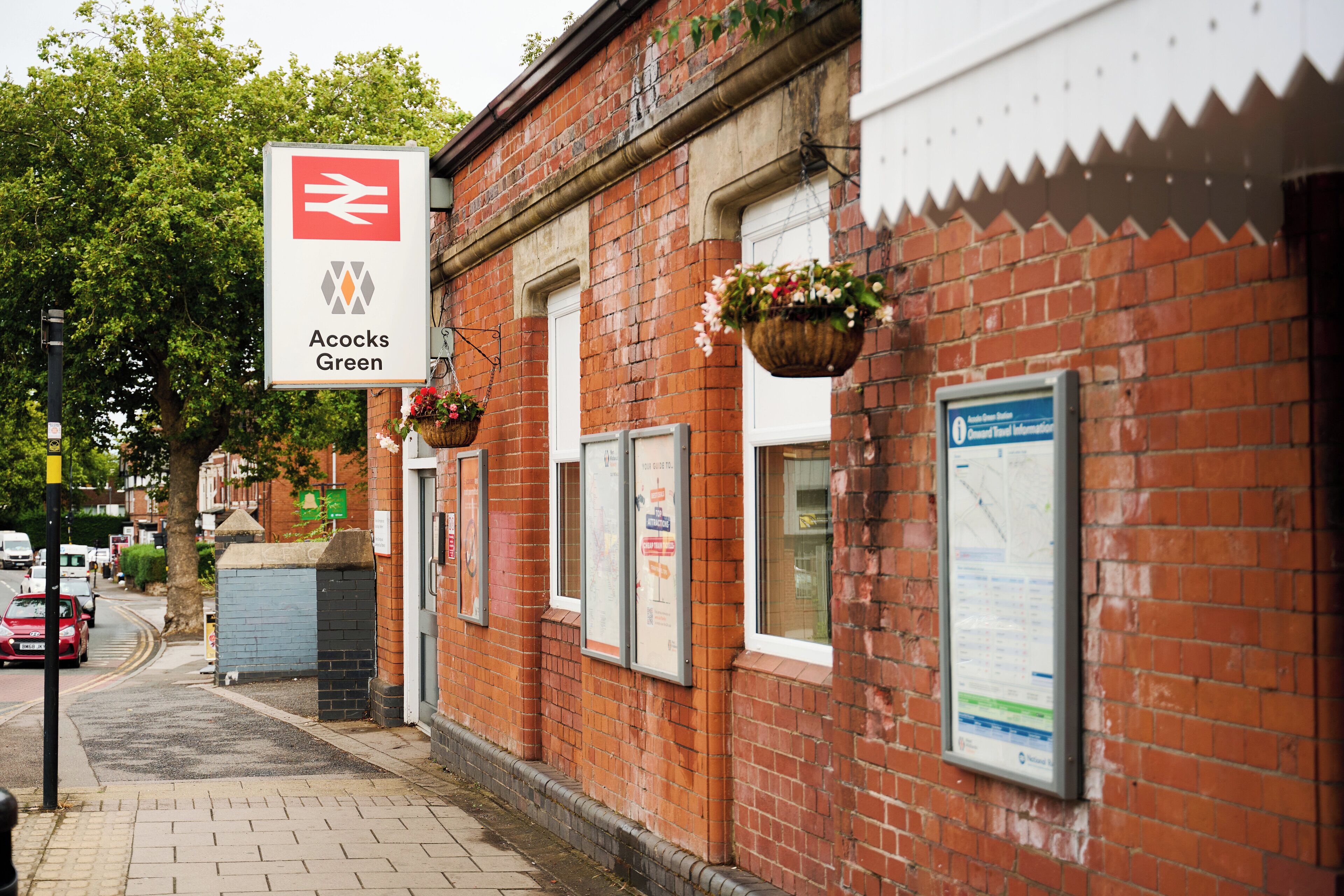 A red brick building with a sign for Acocks Green station.