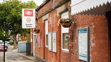 A red brick building with a sign for Acocks Green station.