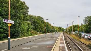 A railway station platform with a sign for Acocks Green.