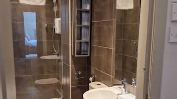 A modern bathroom with a shower, toilet, and sink.