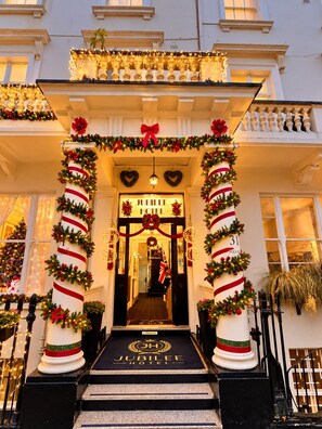 The entrance of Jubilee Hotel with a grand staircase, decorated with festive garlands and lights.