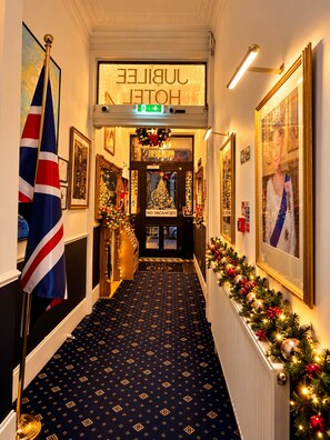 Un vestíbulo de hotel con un árbol de Navidad, un cartel que indica que no hay habitaciones disponibles y una bandera.