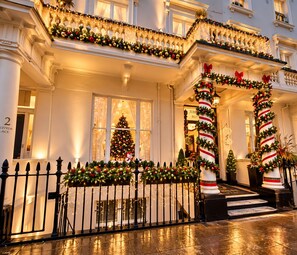 A building with a grand entrance, a Christmas tree, and festive decorations. - Jubilee Hotel Victoria (London)