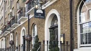 Une rangée d’immeubles en briques, avec une enseigne indiquant «The California», un hôtel.