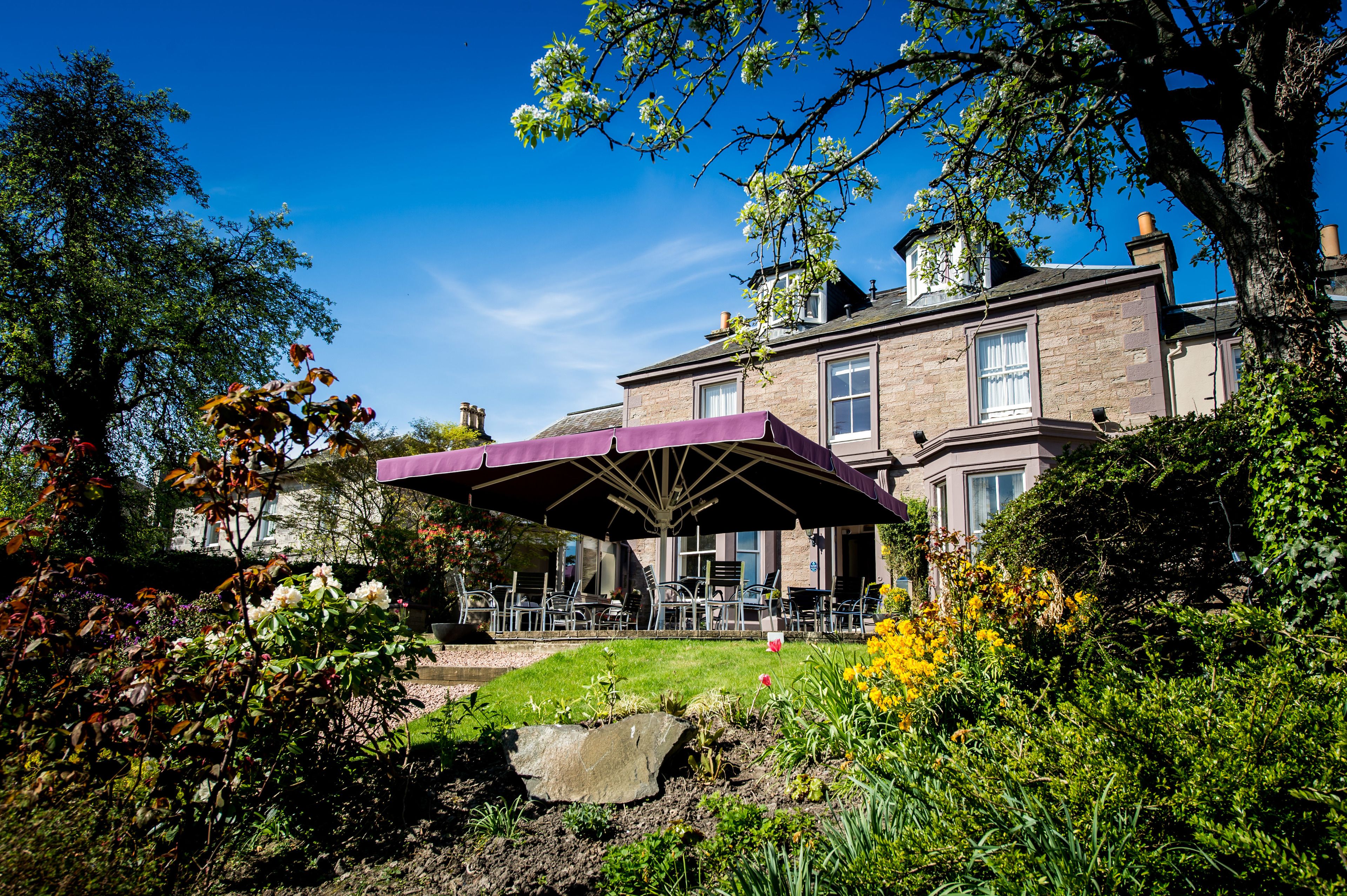 Un grand bâtiment doté d’un patio comprenant un espace extérieur avec des sièges et une partie couverte.