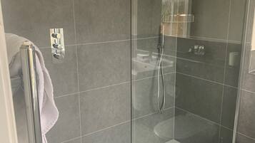 Ein modernes Badezimmer mit einer Duschkabine, einer weißen Badewanne und einem WC.