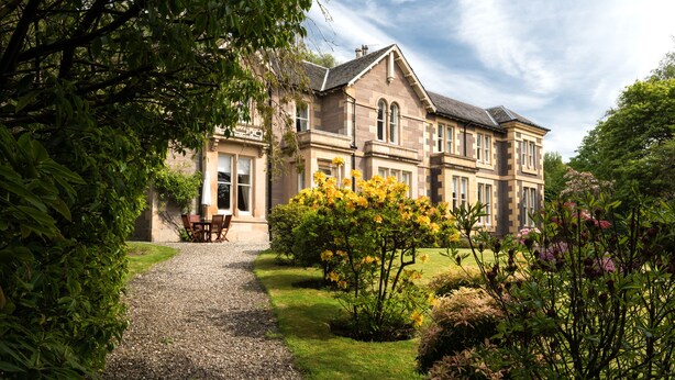 A large, historic building with a gravel pathway leading to a seating area. - Sunbank House Hotel (Perth)