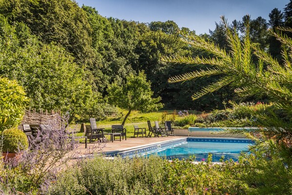 Una piscina al aire libre de temporada, sombrillas