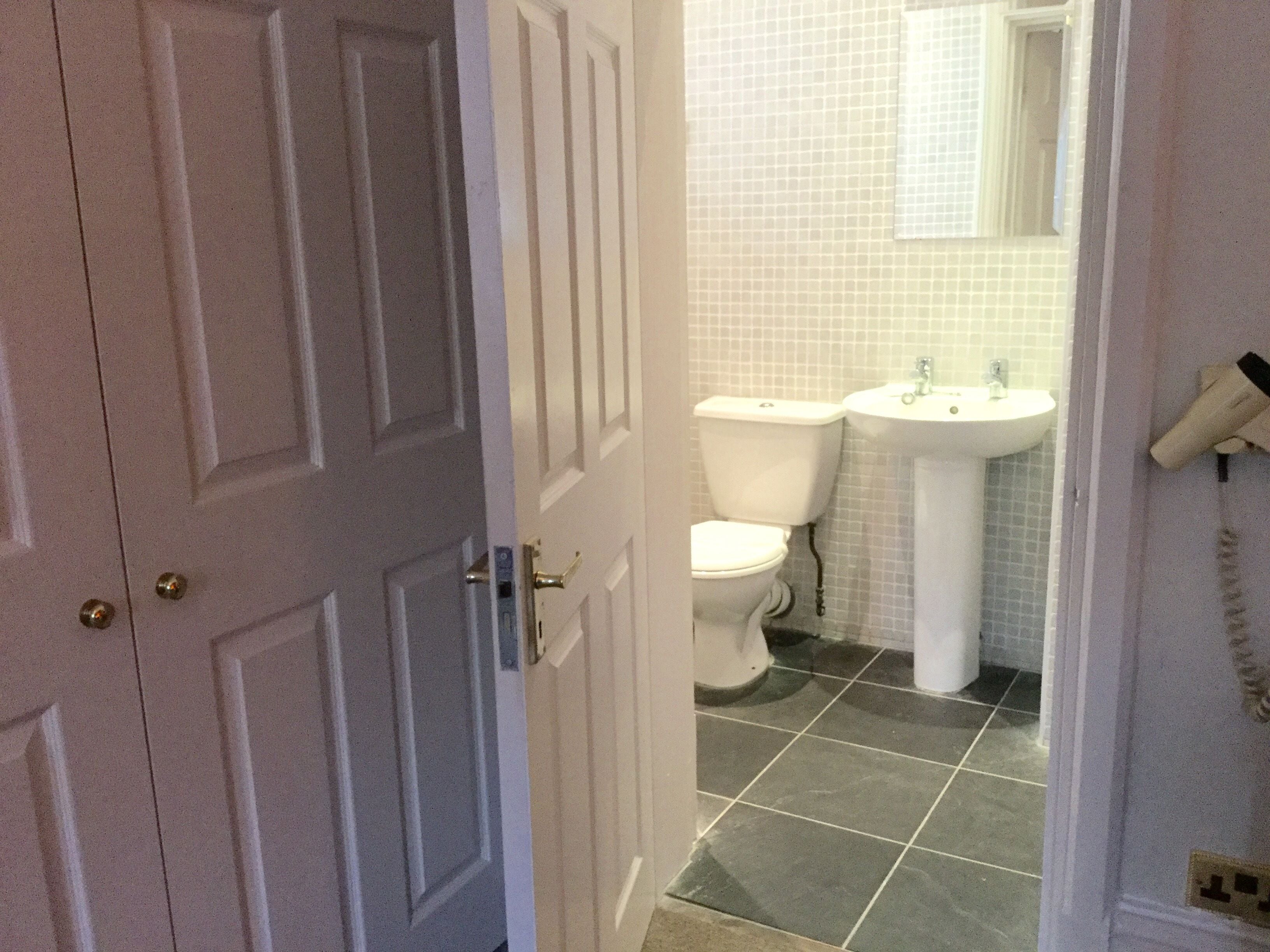 Une salle de bain équipée de toilettes, d’un lavabo et d’un téléphone.
