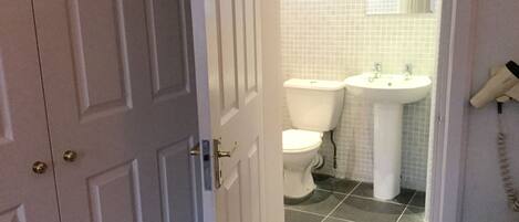 Une salle de bain équipée de toilettes, d’un lavabo et d’un téléphone.