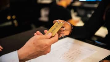 A person holding a keycard with "The Garden" written on it, indicating access to a hotel room.